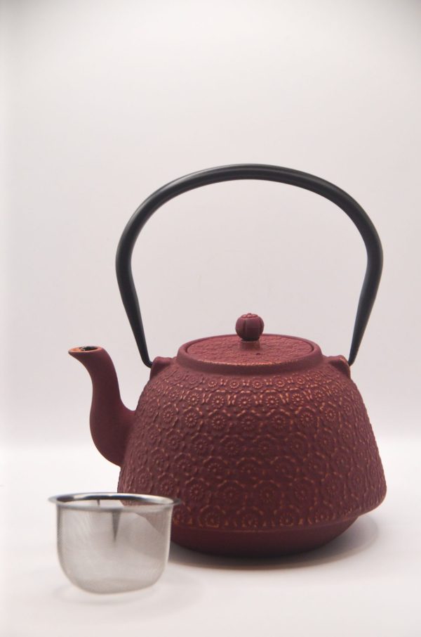 red castiron teapot with basket
